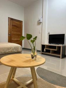 ein Wohnzimmer mit einem Tisch und einer Pflanze darauf in der Unterkunft พรสินี 