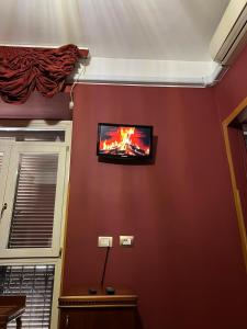 TV de pantalla plana colgada en la pared en Imperial GuestHouse en Roma