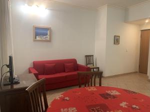 ein Wohnzimmer mit einem roten Sofa und einem Tisch in der Unterkunft Le Macé in Cannes