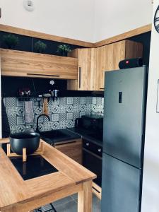 a kitchen with a refrigerator and a wooden table at Appartement design au cœur de Montpellier avec parking privé in Montpellier