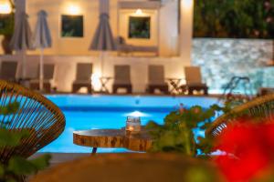 una mesa y sillas frente a una piscina en Aeolos Hotel & Villas - Pelion, en Khorevtón