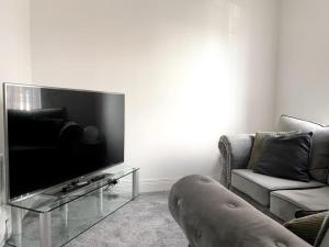 sala de estar con TV de pantalla plana grande en Cosy City Centre Townhouse en Elswick