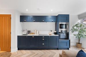 a kitchen with blue cabinets and a stove at Rock Mill 25 in Stony Middleton