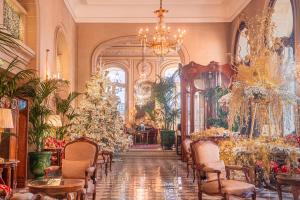 um quarto com uma árvore de Natal e mesas e cadeiras em Hôtel Regina Louvre em Paris