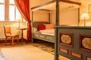 a bedroom with a canopy bed and a chair at Hotel Schloss Büdingen in Büdingen