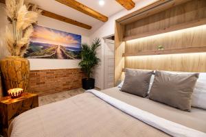 Relax apartmán na Mlejnici في Nové Strašecí: غرفة نوم بسرير ودهان على الحائط