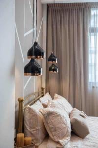 a bedroom with a bed with three lights above it at Condo next to metro st Athens! in Athens