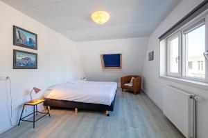 een slaapkamer met een bed en een raam bij Strandhuys Oester De Koog Texel in De Koog