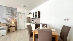 Apartmán Lamba Klínovec في لويكنا بود كلينوفسيم: مطبخ وغرفة طعام مع طاولة وكراسي