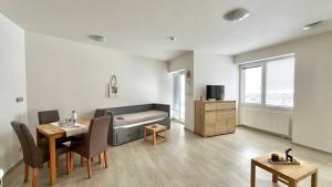 Apartmán Lamba Klínovec في لويكنا بود كلينوفسيم: غرفة معيشة مع حوض استحمام وطاولة وكراسي