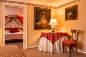 Zimmer mit einem Tisch mit einer Lampe und einem Bett in der Unterkunft Hotel Schloss Büdingen in Büdingen