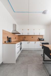 a kitchen with white cabinets and a wooden counter top at BP Hostel / Urbinská 144 in Český Krumlov