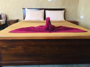 uma cama com um cobertor rosa em Mount Paradise Ella em Ella