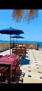 Ramena Beach Hotel في Ramena: صف من الطاولات والكراسي مع مظلات على الشاطئ