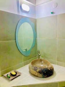 Ramena Beach Hotel في Ramena: حمام مع حوض ومرآة على منضدة