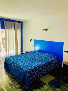 Ramena Beach Hotel في Ramena: غرفة نوم بسرير ازرق مع لحاف ازرق