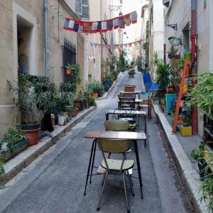 une rue vide avec des tables et des chaises dans une ruelle dans l'établissement Appartement T2 40m2 Rénové Au Coeur du Panier Vieux Port, à Marseille