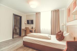 ein Hotelzimmer mit einem Bett und einem Schreibtisch in der Unterkunft Hotel- Restaurant Einklang in Mettingen