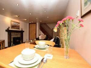 a dining room table with a vase of flowers on it at 1 Bed in Ashford in the Water PK547 in Ashford