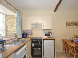 a kitchen with a sink and a stove top oven at 1 Bed in Bourton-on-the-Water 44960 in Withington