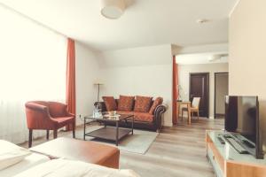 ein Wohnzimmer mit einem Sofa und einem TV in der Unterkunft Hotel- Restaurant Einklang in Mettingen
