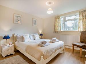 a bedroom with a bed and a chair and a window at 2 Bed in Charmouth 50033 in Blackpool Corner