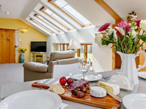 a table with cheese and meats and a vase with flowers at 2 Bed in Axminster 45096 in Axminster