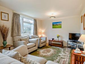 a living room with a couch and a tv at 2 Bed in Charmouth 50033 in Blackpool Corner