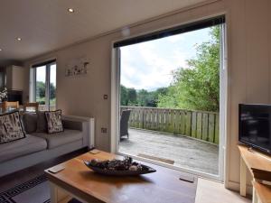 a living room with a large sliding glass door at 2 Bed in Conwy 50284 in Llangelynin