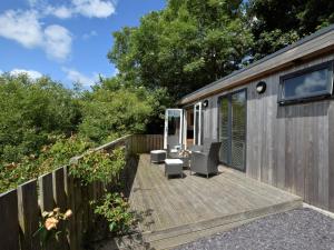 a wooden deck with chairs and a house at 2 Bed in Conwy 50284 in Llangelynin