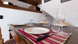 a table with a plate and wine glasses on it at Italianway - Osteglio 15 Frodolfo in Valdisotto