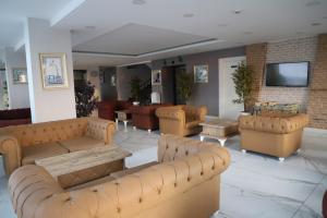 eine Lobby mit Sofas, Tischen und einem TV in der Unterkunft Lara Garden Hotel in Lara