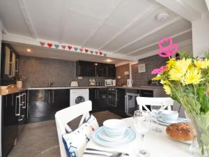 eine Küche mit einem Tisch und einer Vase aus Blumen in der Unterkunft 2 bed in Brixham BX021 in Brixham