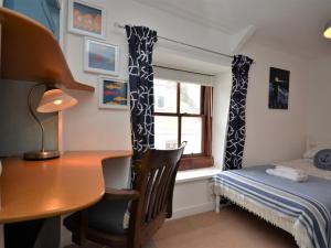 Schlafzimmer mit einem Schreibtisch, einem Bett und einem Fenster in der Unterkunft 2 bed in Brixham BX021 in Brixham
