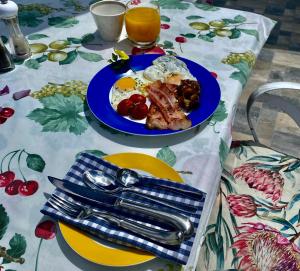 a table with a blue plate of breakfast food on it at The View Swellendam B&B in Swellendam