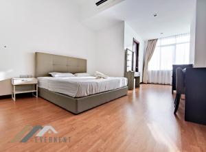 a bedroom with a large bed and a wooden floor at Bay Resort by Evernent in Miri
