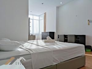 a large white bed with a towel on top of it at Bay Resort by Evernent in Miri