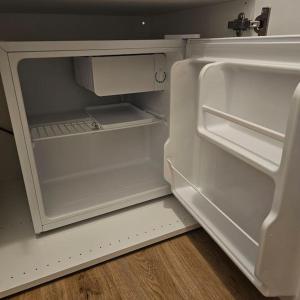 an empty refrigerator with its door open in a kitchen at Fewo am premium Wanderort in Bad Berleburg