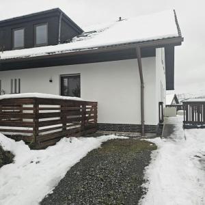 ein Haus mit einem Zaun und Schnee darauf in der Unterkunft Fewo am premium Wanderort in Bad Berleburg