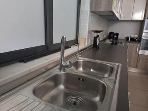 a stainless steel sink in a kitchen with a window at Door 51 in St. Julianʼs