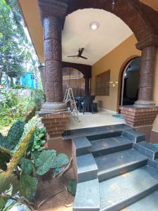 Villa Portuguese 2bhk house candolim goa في أنجونا: منزل مع شرفة مع درج حجري
