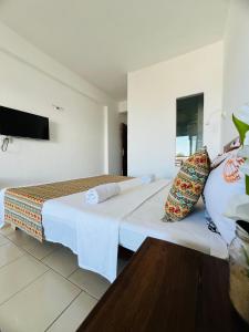 a hotel room with a bed and a tv at Hôtel Ambatoloaka in Nosy Be