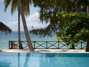 a swimming pool with a view of the ocean at MANOLO Beach Resort in Uroa