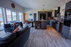 a living room with a couch and a kitchen at Birches Lodge with Hot Tub in Dundonnell