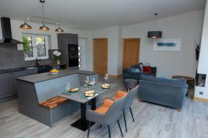 Birches Lodge with Hot Tub في Dundonnell: مطبخ وغرفة معيشة مع طاولة وكراسي