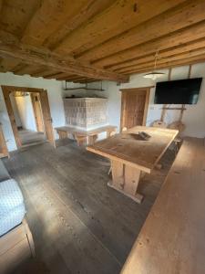 a large room with a wooden table and a tv at La Baita di Aclete in Tarvisio