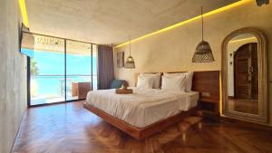 um quarto com uma cama grande e uma janela grande em Shore Thing Gili Air Beachfront Apartment em Gili Air