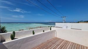 a view of the ocean from the balcony of a house at Shore Thing Gili Air Beachfront Apartment in Gili Air
