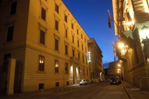 nachts eine Stadtstraße mit vor einem Gebäude geparkt in der Unterkunft Hotel Beatrice in Florenz