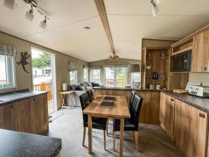 a kitchen and dining room with a table and chairs at Beautiful 6 Berth Caravan At Caldecott Hall Country Park, Norfolk Ref 91150c in Great Yarmouth